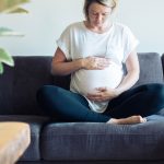 picture of a pregnant woman on a couch who knows about getting pregnant with PCOS