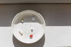 picture of a white bowl with 5 vitamins in it including magnesium and pcos supplements