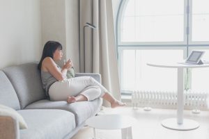 picture of an Asian woman sitting out a couch with PCOS and perimenopause