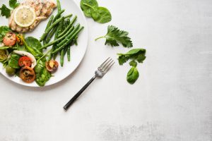 picture of a plate with a low GI diet for PCOS including chicken breast, green beans and a salad
