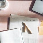 picture of a desk with pcos lab tests, a laptop and glass of water